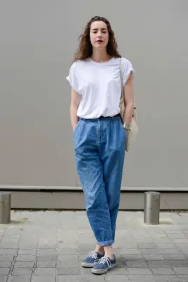 With a White Tee Tucked Into Baggy Denim Pants