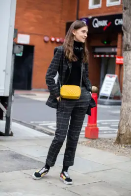With a Plaid Suit, Turtleneck, and Bright Purse