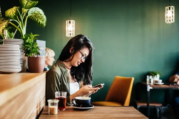 Woman Looking at Phone at Restaurant