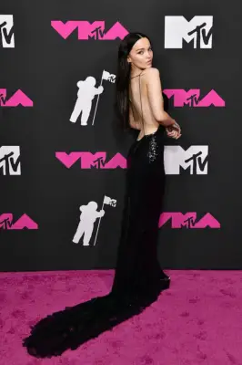 Dove Cameron Wearing a Backless Dress