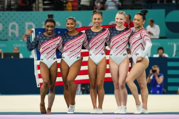 PARIS, FRANCE - JULY 30: Simone Biles of United States, Jade Carey of United States, Jordan Chiles of United States, Sunisa Lee of United States and Healy Rivera of United States celebrate on the podium for winning the gold medal during Women