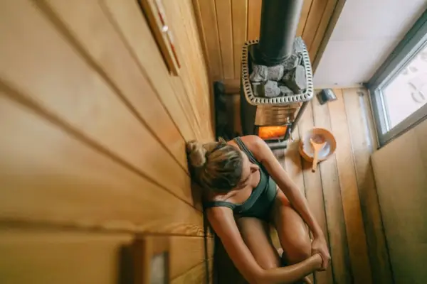 Photo of a young woman relaxing in sauna she is at and enjoying her spa day.