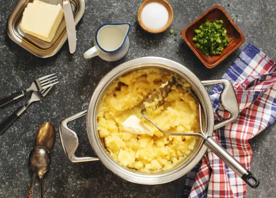 fluffy (not gluey) mashed potatoes in cooking pan on wooden table