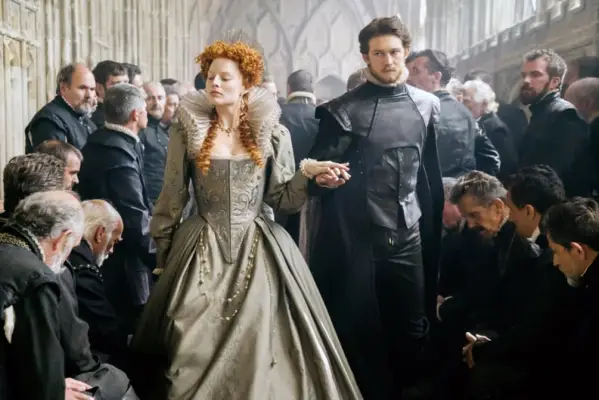 MARY QUEEN OF SCOTS, center from left: Margot Robbie as Queen Elizabeth I, Joe Alwyn as Robert Dudley, 2018. ph: Liam Daniel. Focus Features /Courtesy Everett Collection