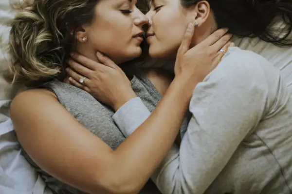 Lesbian Couple Kissing In Bed