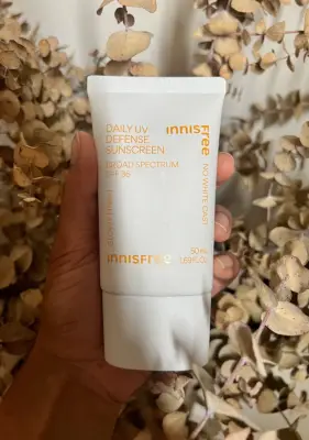 Woman holding the Innisfree Daily UV Defense Sunscreen.