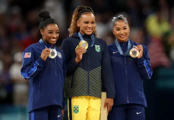 PARIS, FRANCE - AUGUST 05: Gold medalist Rebeca Andrade (C) of Team Brazil, silver medalist Simone Biles (L) of Team United States and bronze medalist Jordan Chiles (R) of Team United States pose on the podium at the Artistic Gymnastics Women
