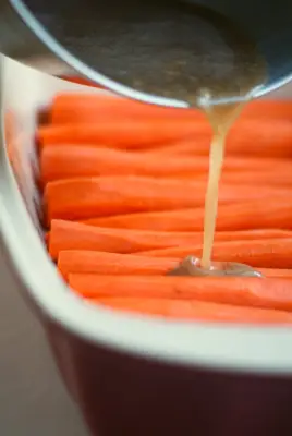Cinnamon Butter Baked Carrots recipe: covering carrots in cinnamon butter sauce