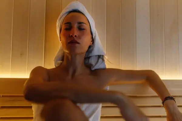 Woman relaxing in the hot sauna at her home bathroom.