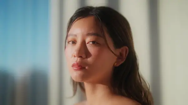 Young Woman In Room Looking at Camera